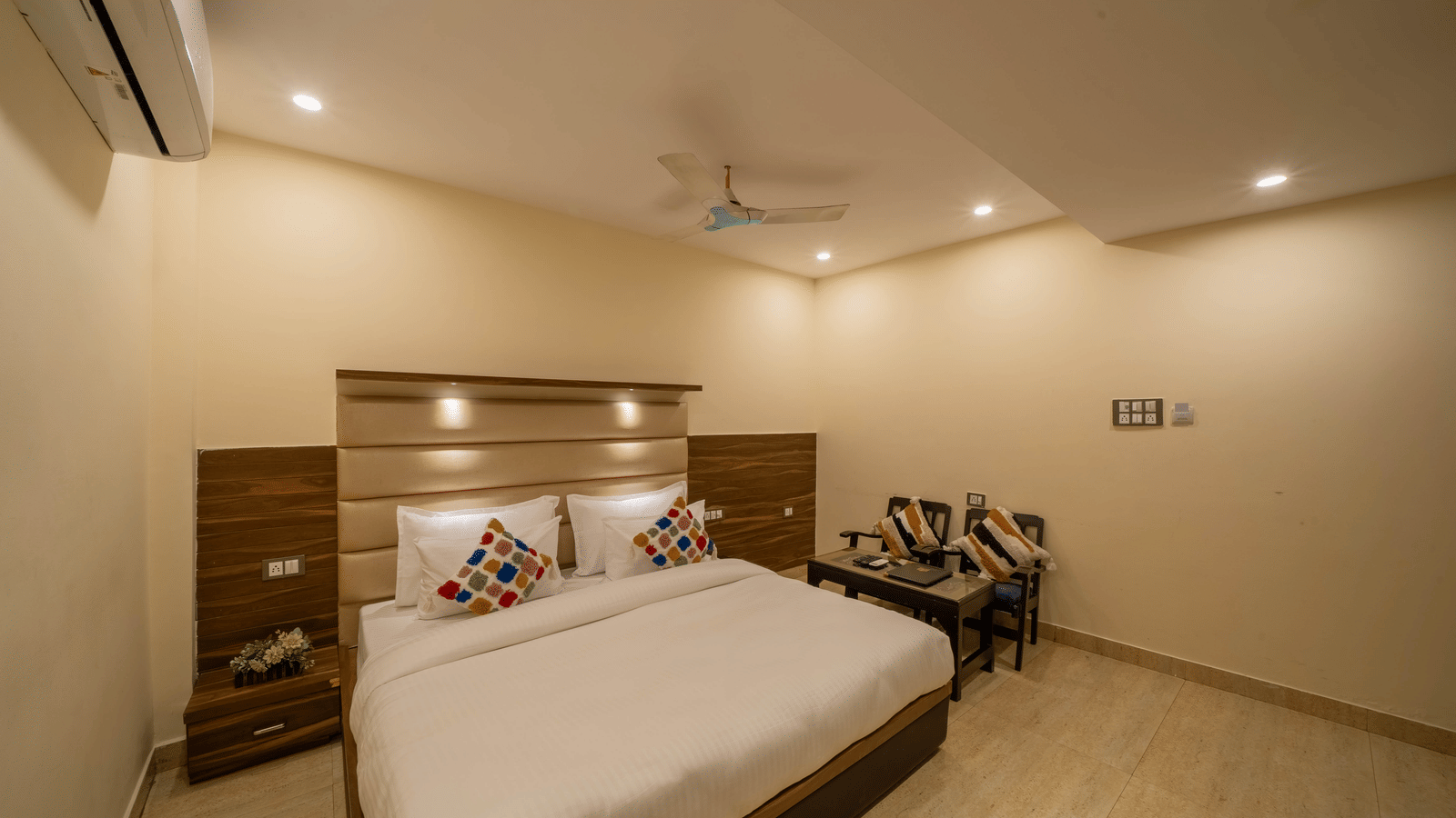 Spacious, minimalist hotel room with a minimalist design, wooden headboard, and a ceiling fan - Perfectstayz Premium at Har Ki Pauri Road (Ganga Heights)