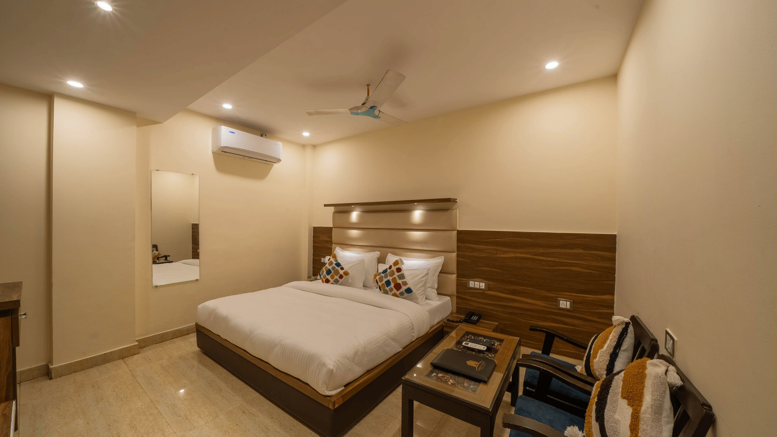 Spacious hotel room featuring a well-made bed, wooden headboard, seating area, and bedside tables - Perfectstayz Premium at Har Ki Pauri Road (Ganga Heights)