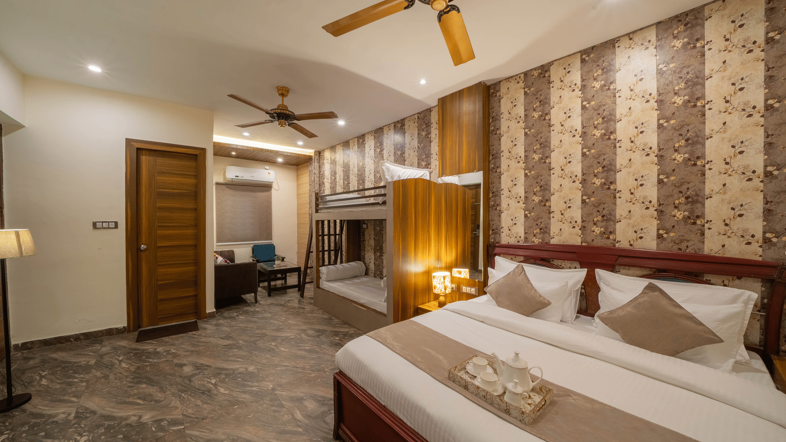 Spacious hotel room with a large bed, ceiling fan, and prominent striped wallpaper - Perfectstayz Premium at Har Ki Pauri Road (Ganga Heights)