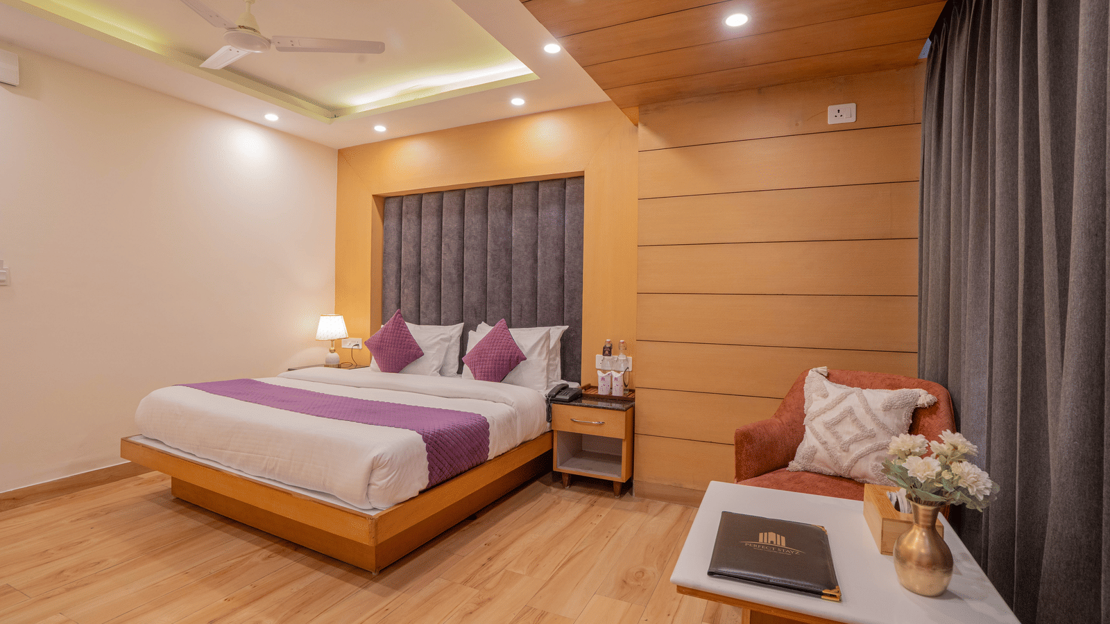 A bedroom with a king size bed, bedside tables, and lamps at Perfectstayz Premium at Mall Road Hotel Super, Mussoorie.