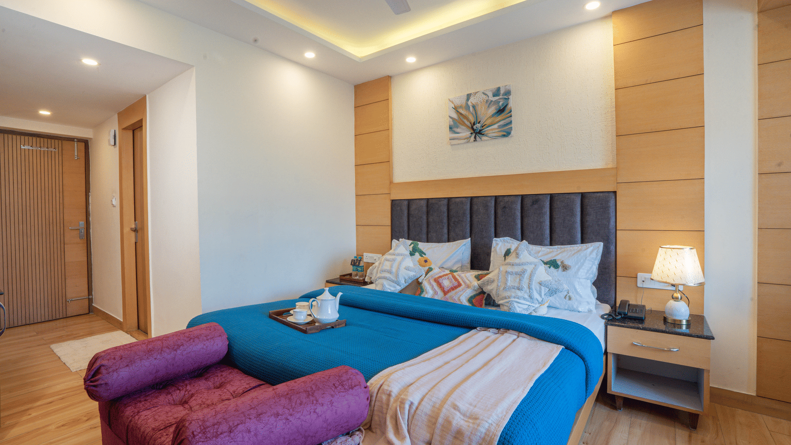 A bedroom with a king size bed, a seating area, and wall art at Perfectstayz Premium at Mall Road Hotel Super, Mussoorie.
