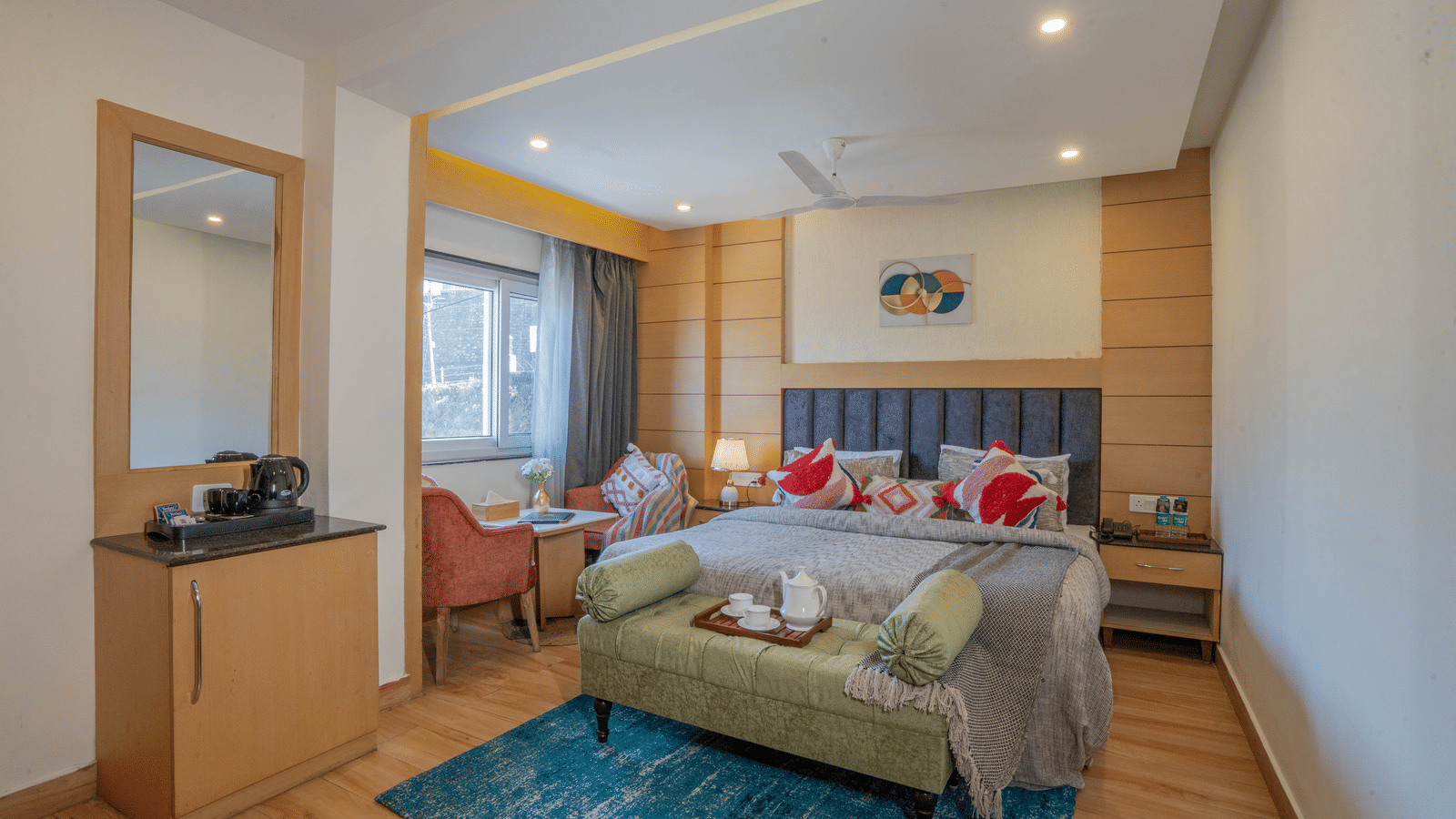 A bedroom with a bed, sofa, and rug near window at Perfectstayz Premium at Mall Road Hotel Super, Mussoorie.