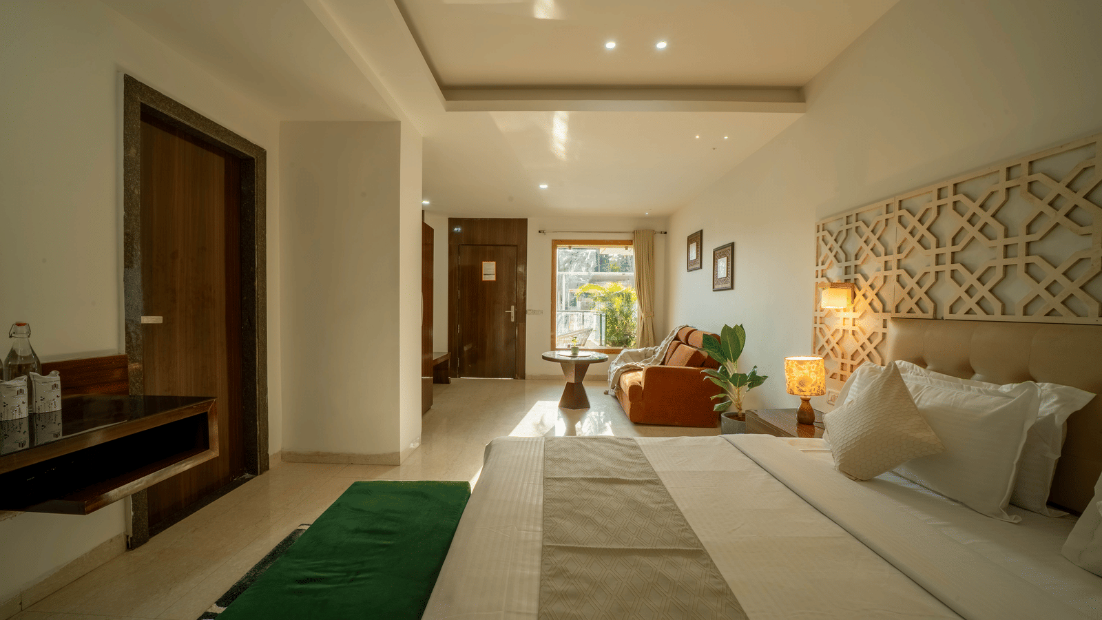 An elegant and luxurious room at Perfectstayz Premium Goa Continental with a king size bed, stylish lighting, and green accent rugs.