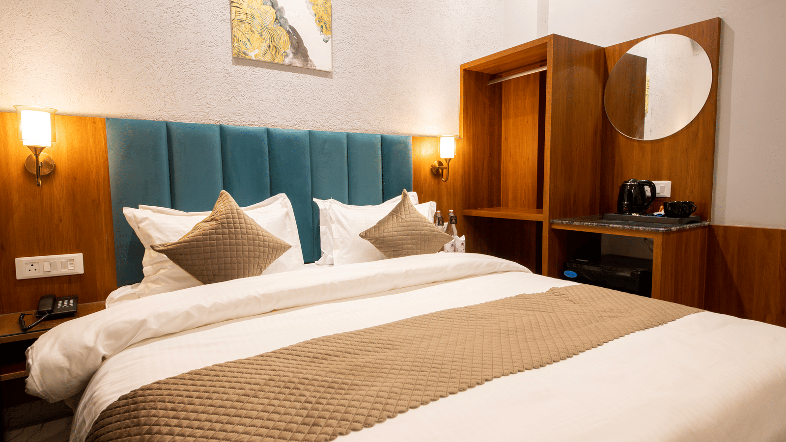 A bedroom with a king size bed, wooden wardrobe, and wall lamps at Perfectstayz Premium Laxmi Heritage.