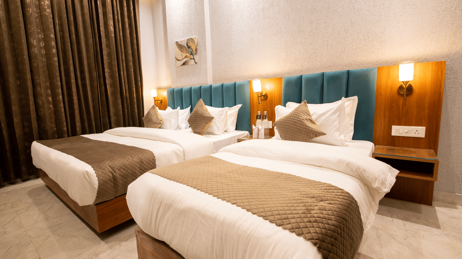 A bedroom with 1 king size bed, 1 single bed with 3 nightstands, and wall lamps in a room at Perfectstayz Premium Laxmi Heritage.