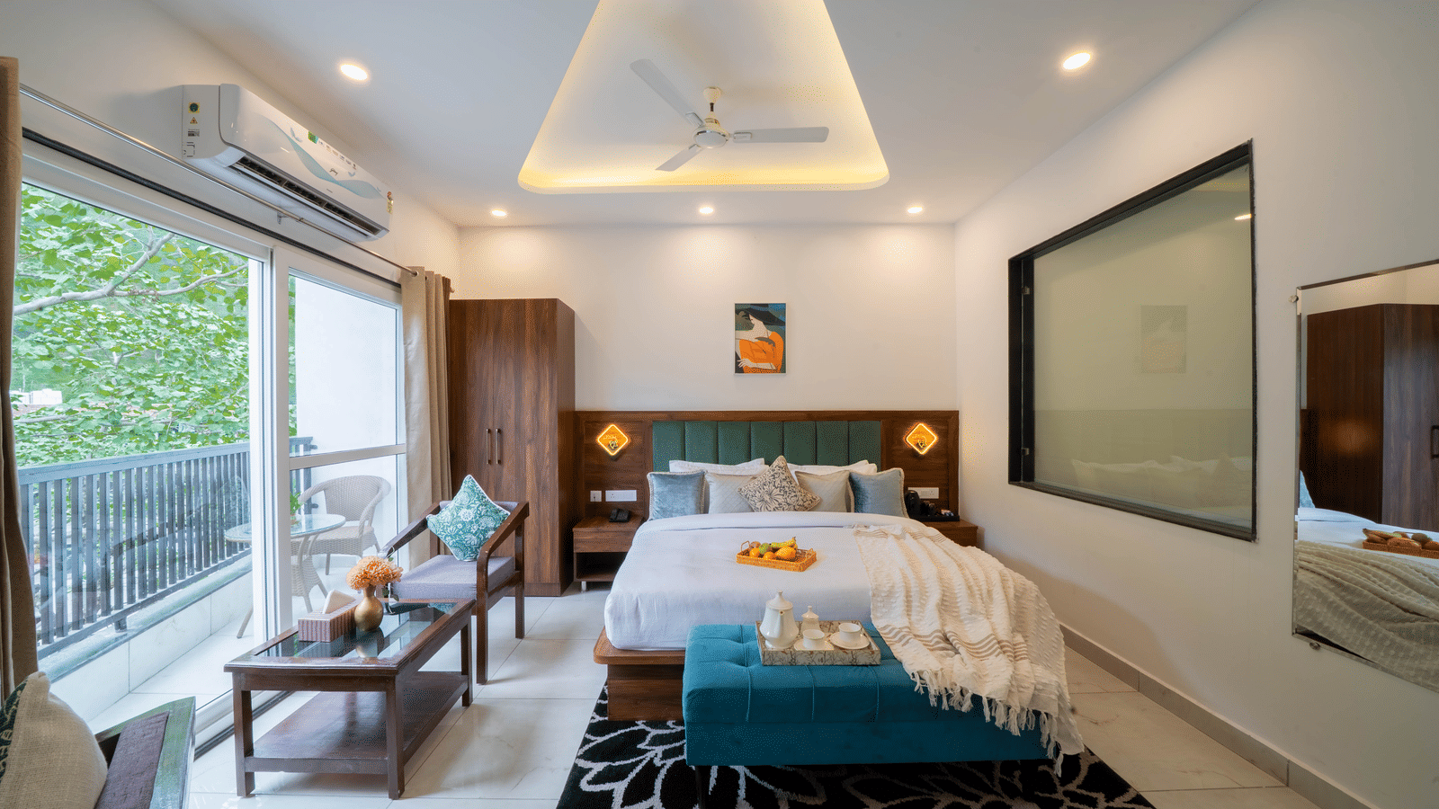 A room with a bed, a headboard, a bench at the foot of the bed, a television, and a sliding door leading to an outdoor area in Perfectstayz Premium Mystic Falls, Rishikesh.