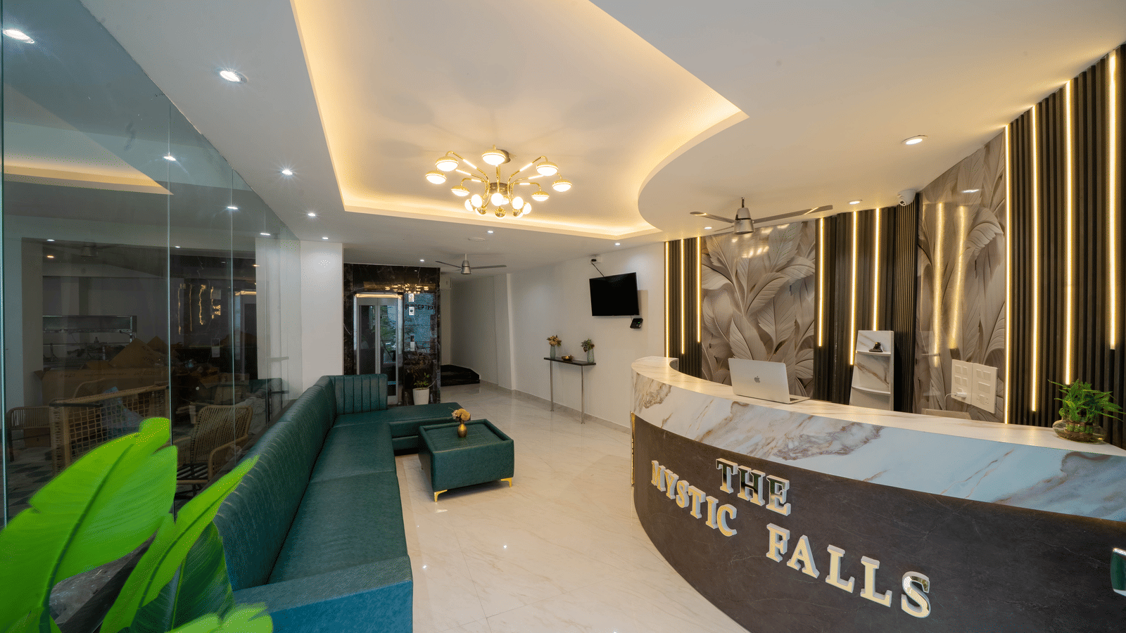 A reception area with a desk, a sign with letters, and seating along the wall in Perfectstayz Premium Mystic Falls, Rishikesh.