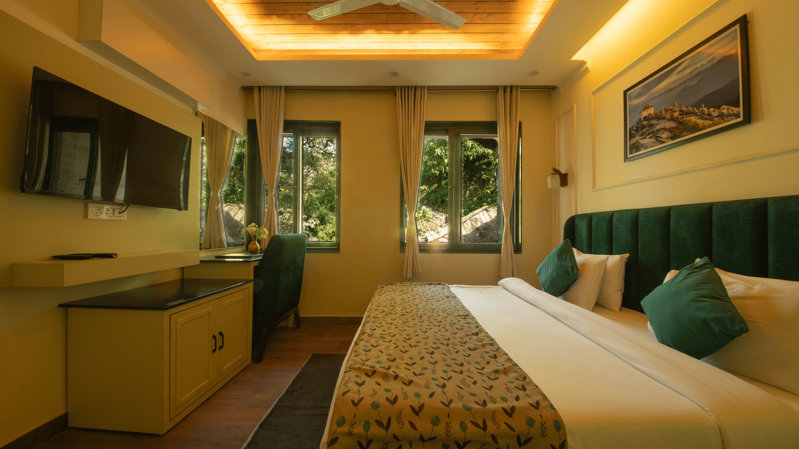 Full view of the Deluxe Room featuring a plush double bed along with 2 windows overlooking the lush green surrounding in the exterior at Perfectstayz Premium Westend Mall Road, Mussoorie.