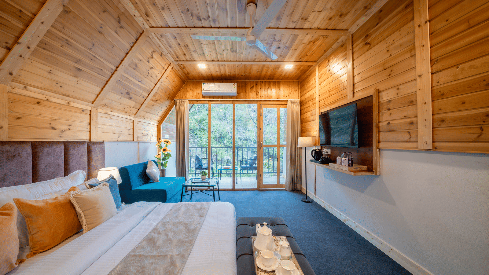 A loft bedroom at Perfect Stayz The Jungle Resort has a bed, a television, and a sofa.