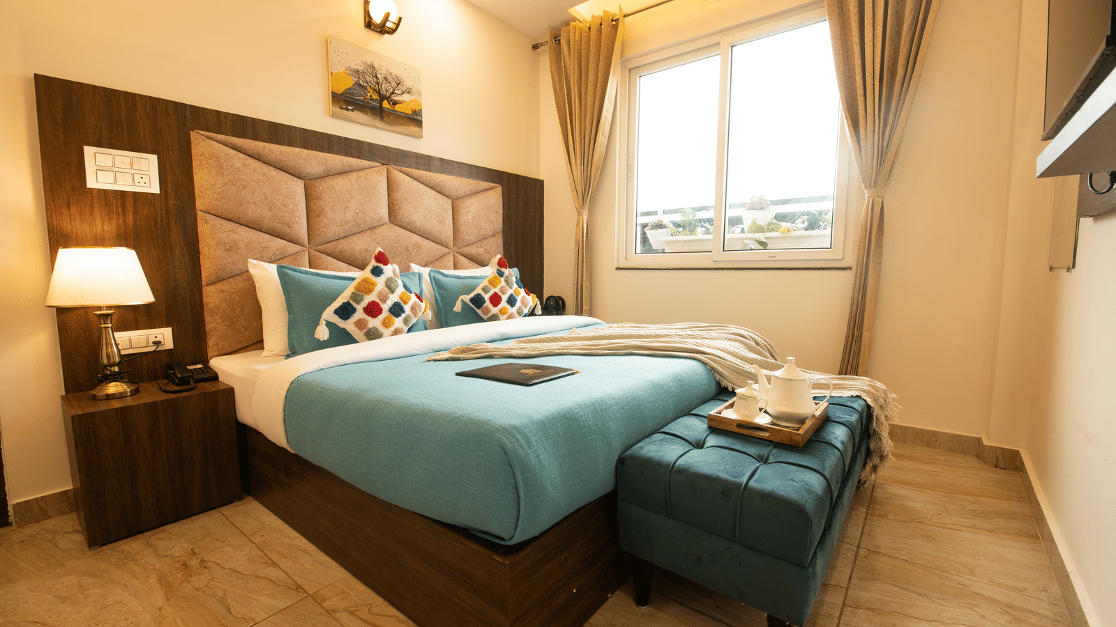 A corner-view shot taken from a lower angle of the double bed at the Executive Room with ample of natural light coming from the window beside it at the Perfectstayz Value Dhruv Nanda.