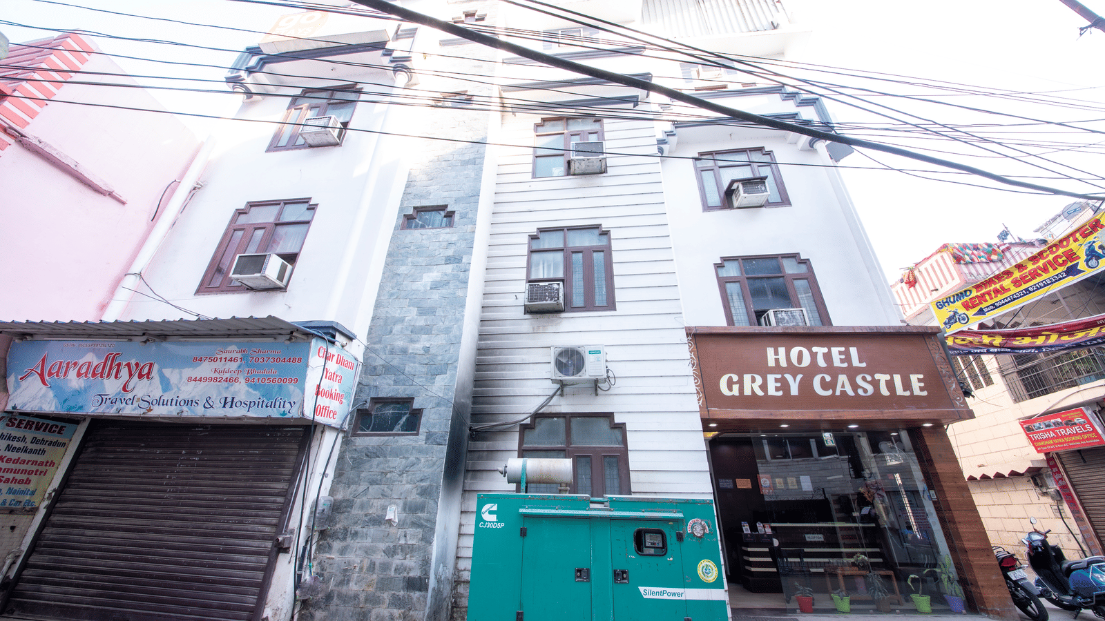 Exterior view of a multi-storey building, with many electrical lines passing through the front - Perfectstayz Value Grey Castle, Haridwar 
