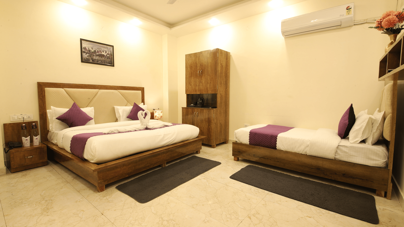 A hotel room, featuring 2 beds with white linens and purple accent runner, a dark wooden headboard and frame, nightstands, and beige tiled floor | Perfectstayz Value Hills, Rishikesh