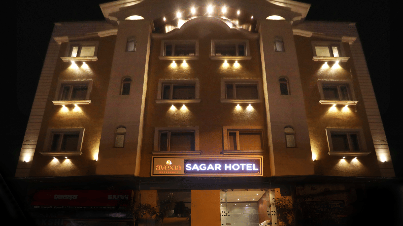 The exterior of a multi-storey hotel building illuminated at night, with a sign that reads 'SAGAR HOTEL' | Perfectstayz Value Sagar