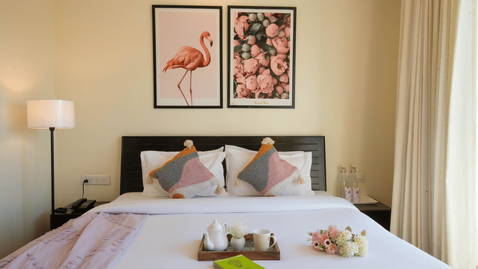 A bedroom at Perfectstayz Value Shimla (Namah Retreat) featuring a king size bed, wall art, side lamp, and a tray with a cup and kettle on the bed.