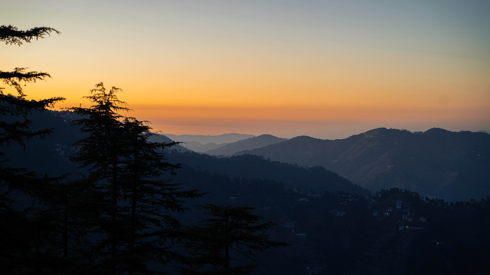 A sunset view over distant hills and trees near Perfectstayz Value Shimla (Namah Retreat).