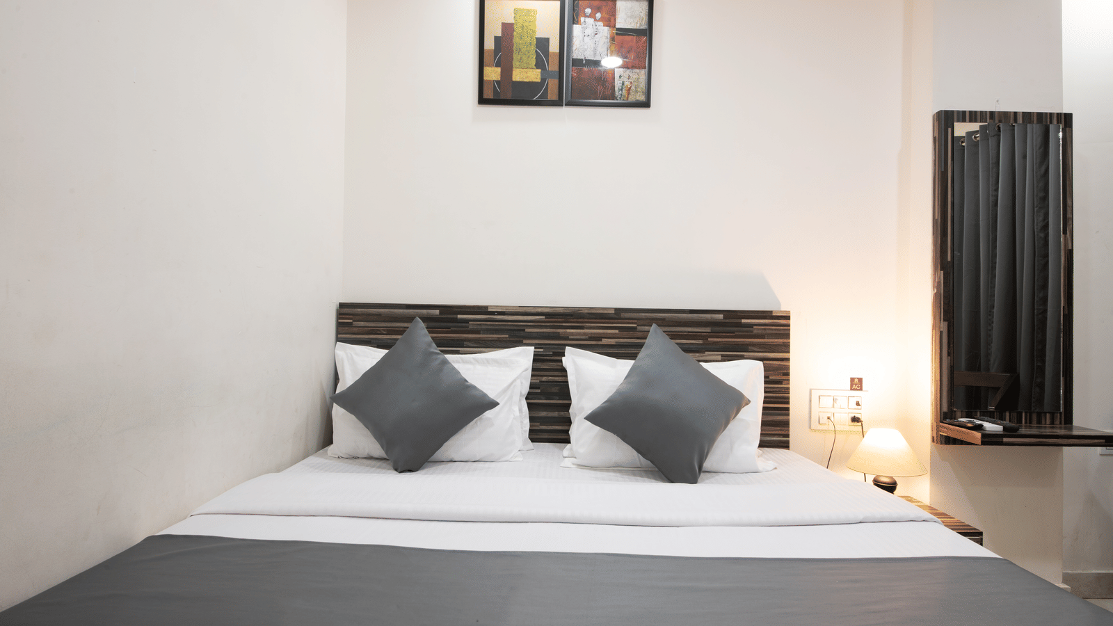 Well-lit bedroom with neatly arranged pillows and bed - Perfectstayz Value Umra Grace, Haridwar