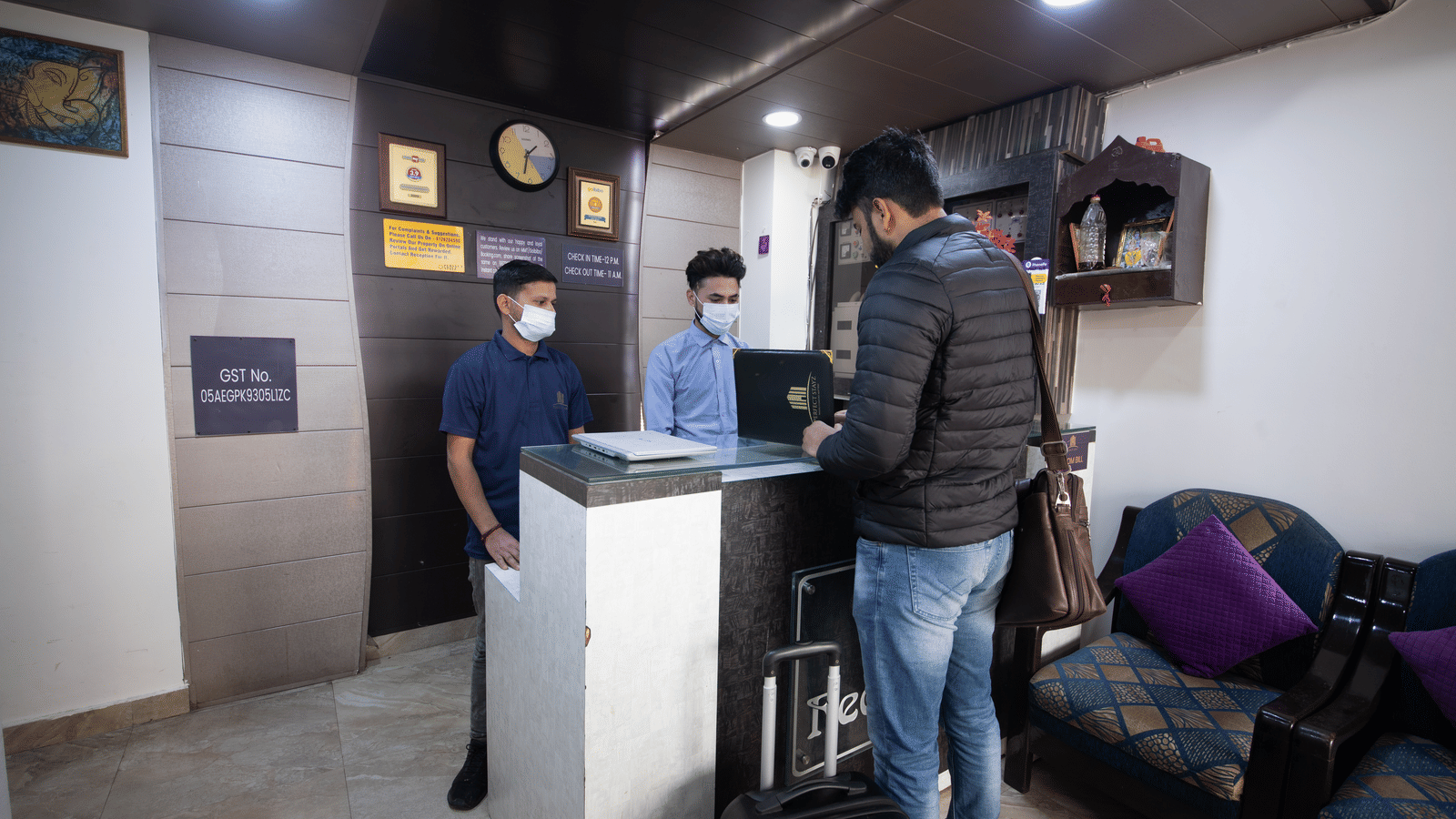 Reception area with staff assisting guests - Perfectstayz Value Umra Grace, Haridwar