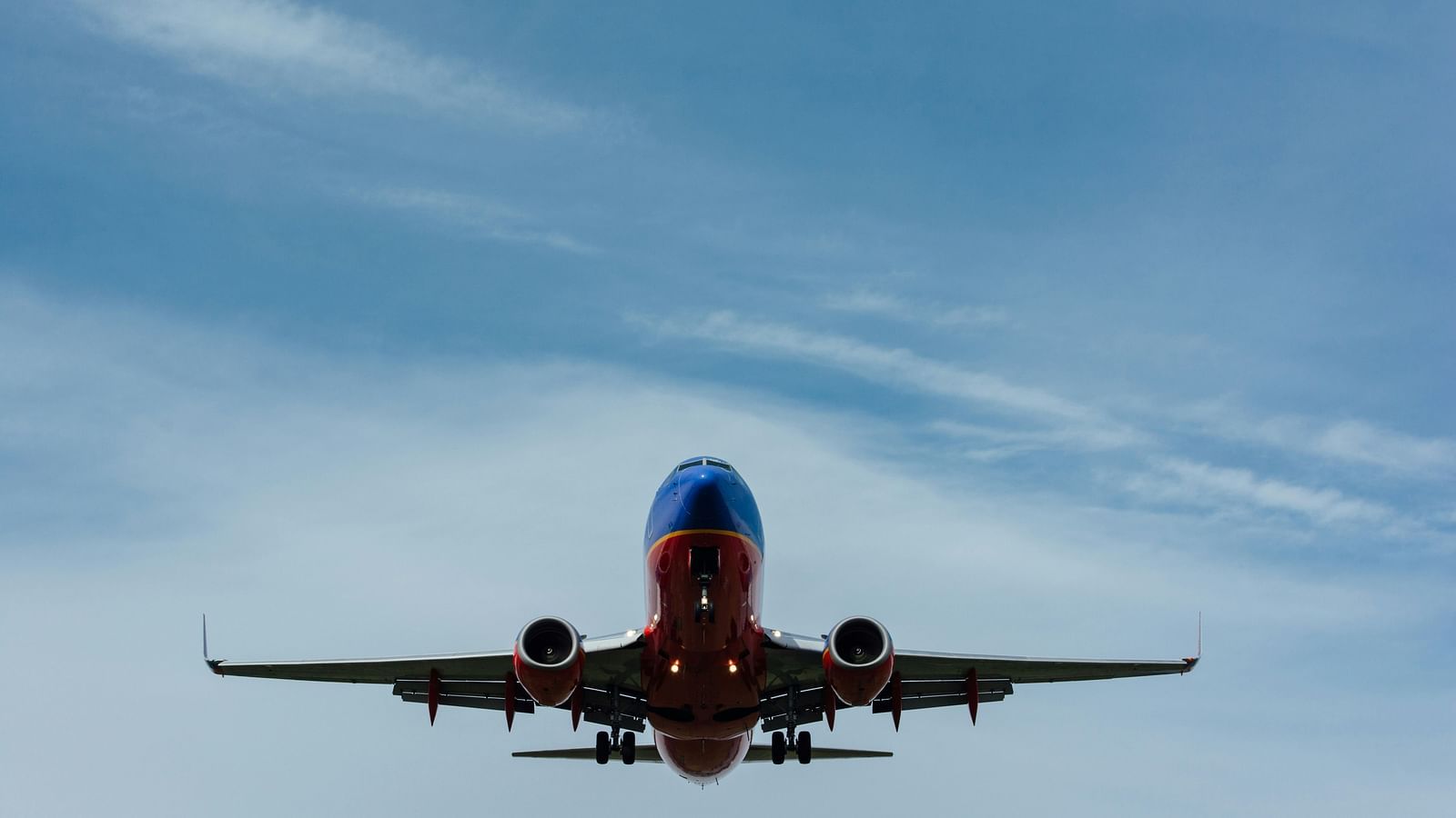 View of an aeroplane in the air with clear blue sky in the background.