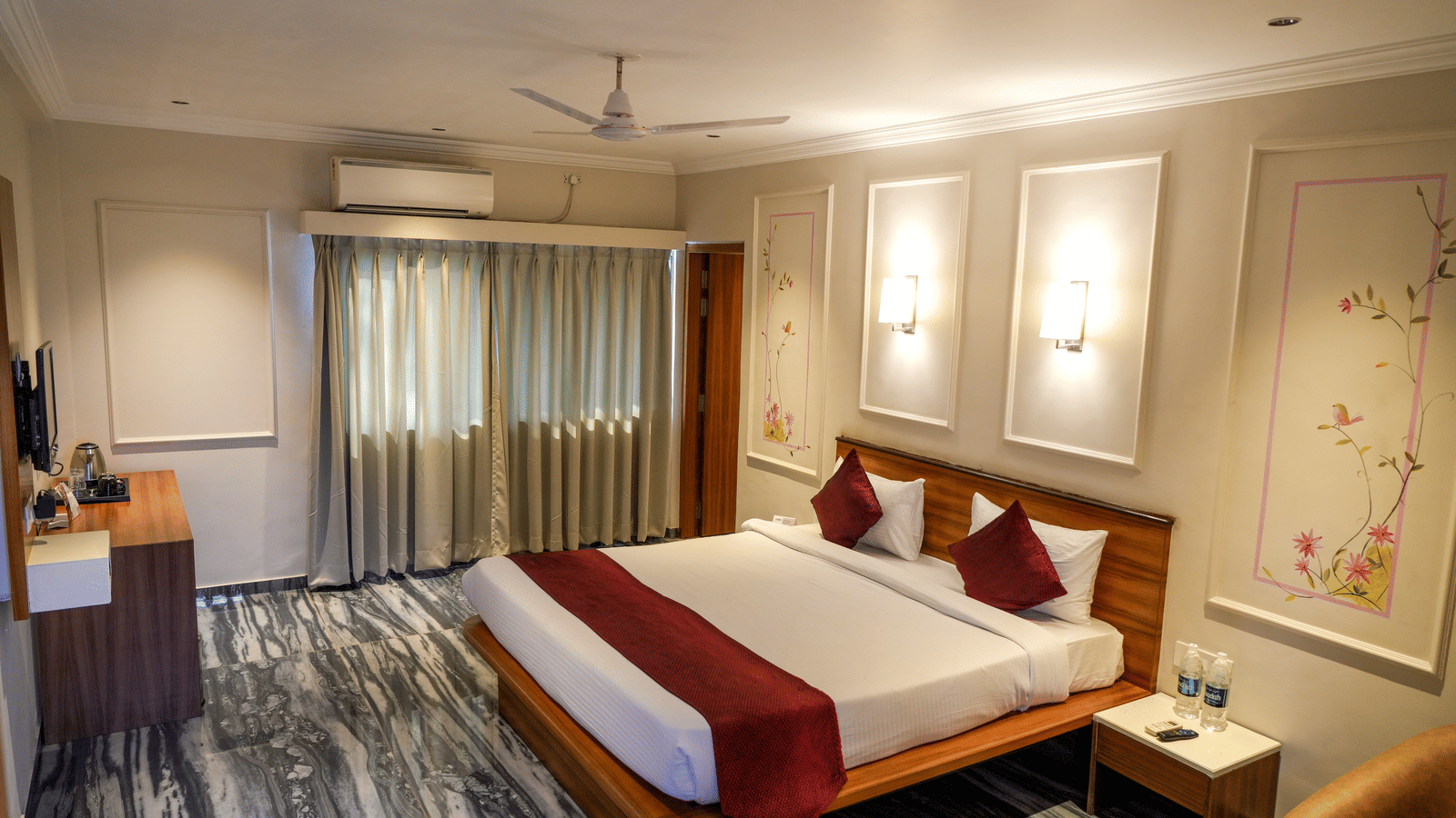  A well-designed deluxe bedroom with striking black and white patterned flooring and recessed wall lights at Pravasa Hotel, Kolhapur. 