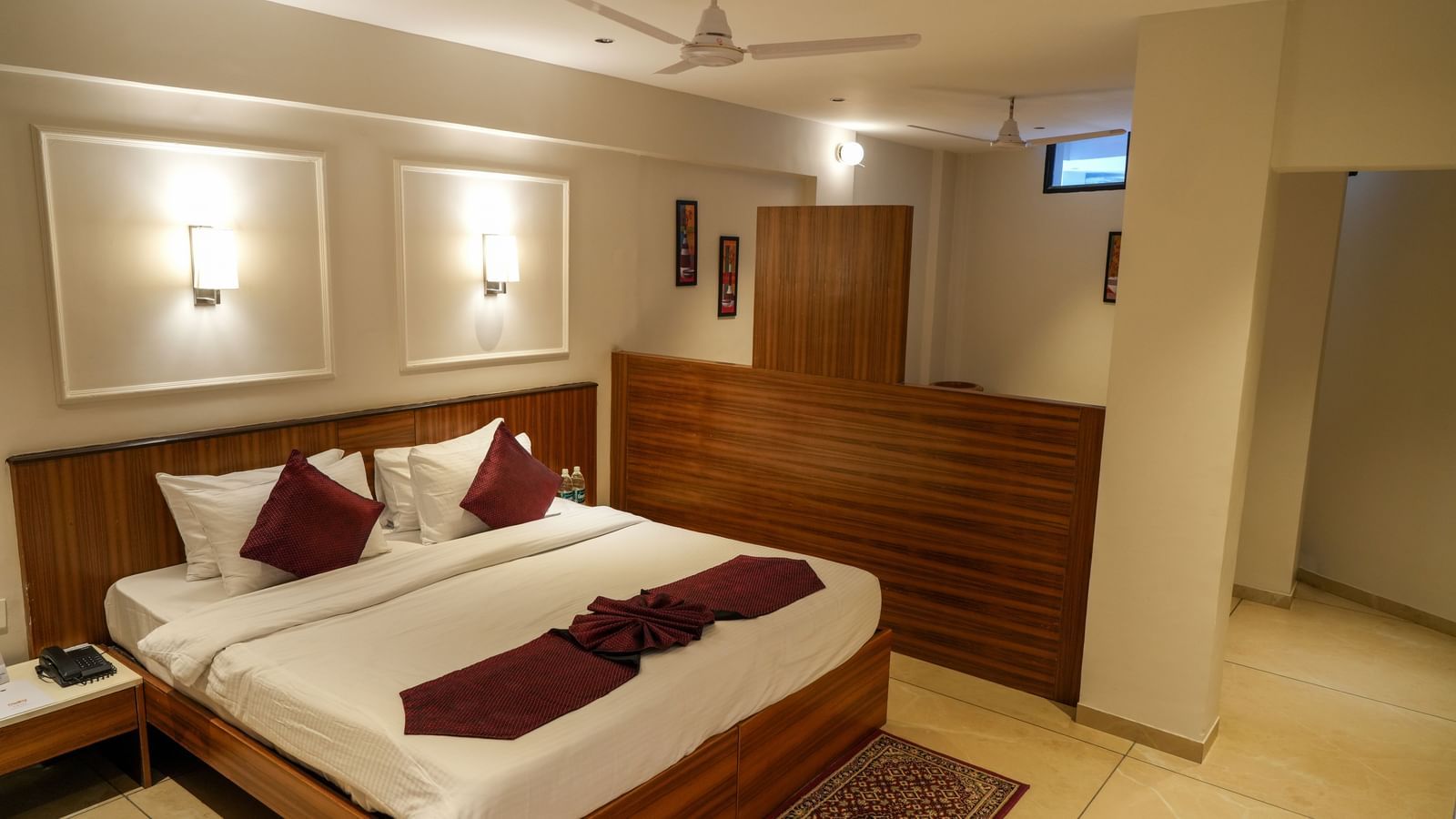 Spacious guest room with a large double bed and modern interiors at Pravasa Hotel Kolhapur.