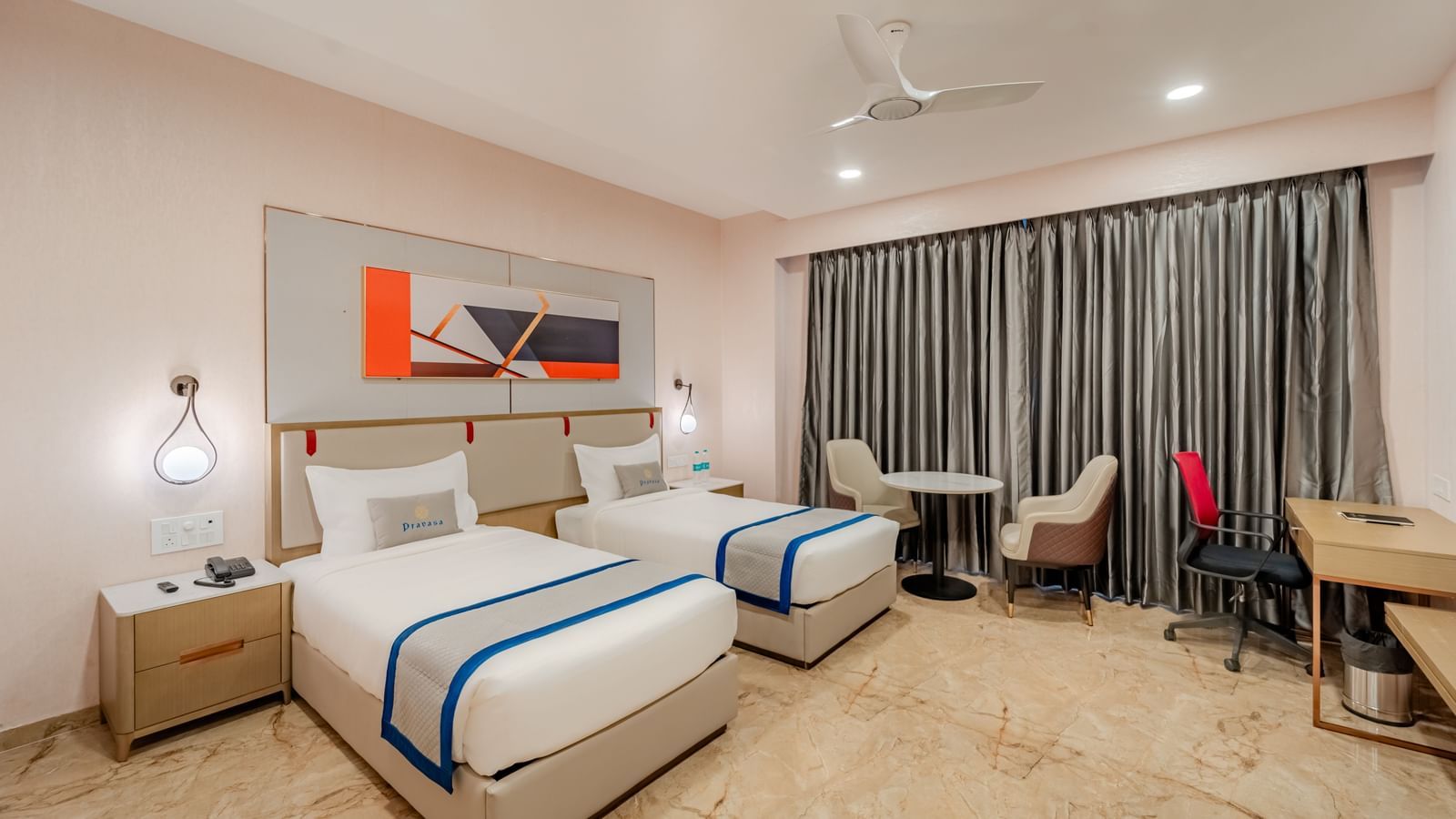 A hotel room with twin beds, a desk, and modern decor | Superior Room | Pravasa Hotel, Vijayapura