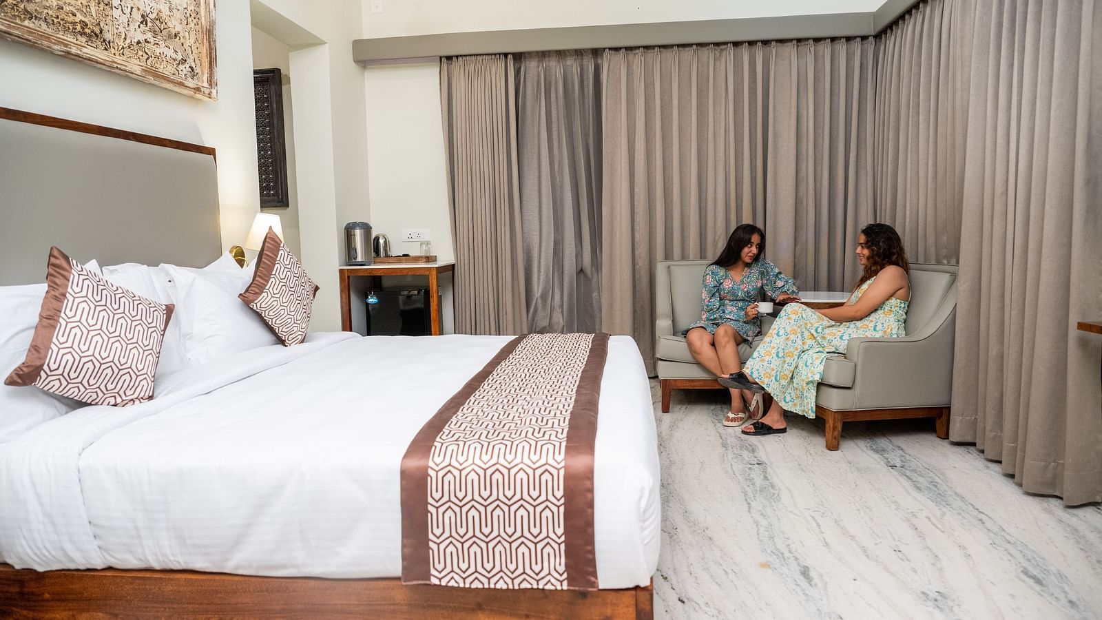 An image of women sitting on couch in one of our rooms in Udaipur - Rajbagh Wellness, Udaipur