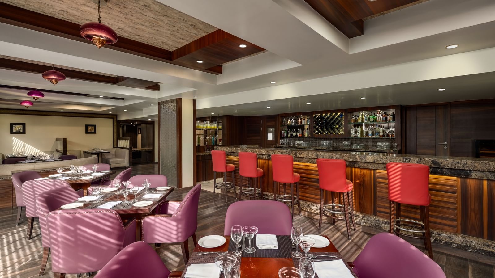 Restaurant dining space with turquoise chairs and modern ceiling design at Ramada by Wyndham Ghaziabad Vasundhara