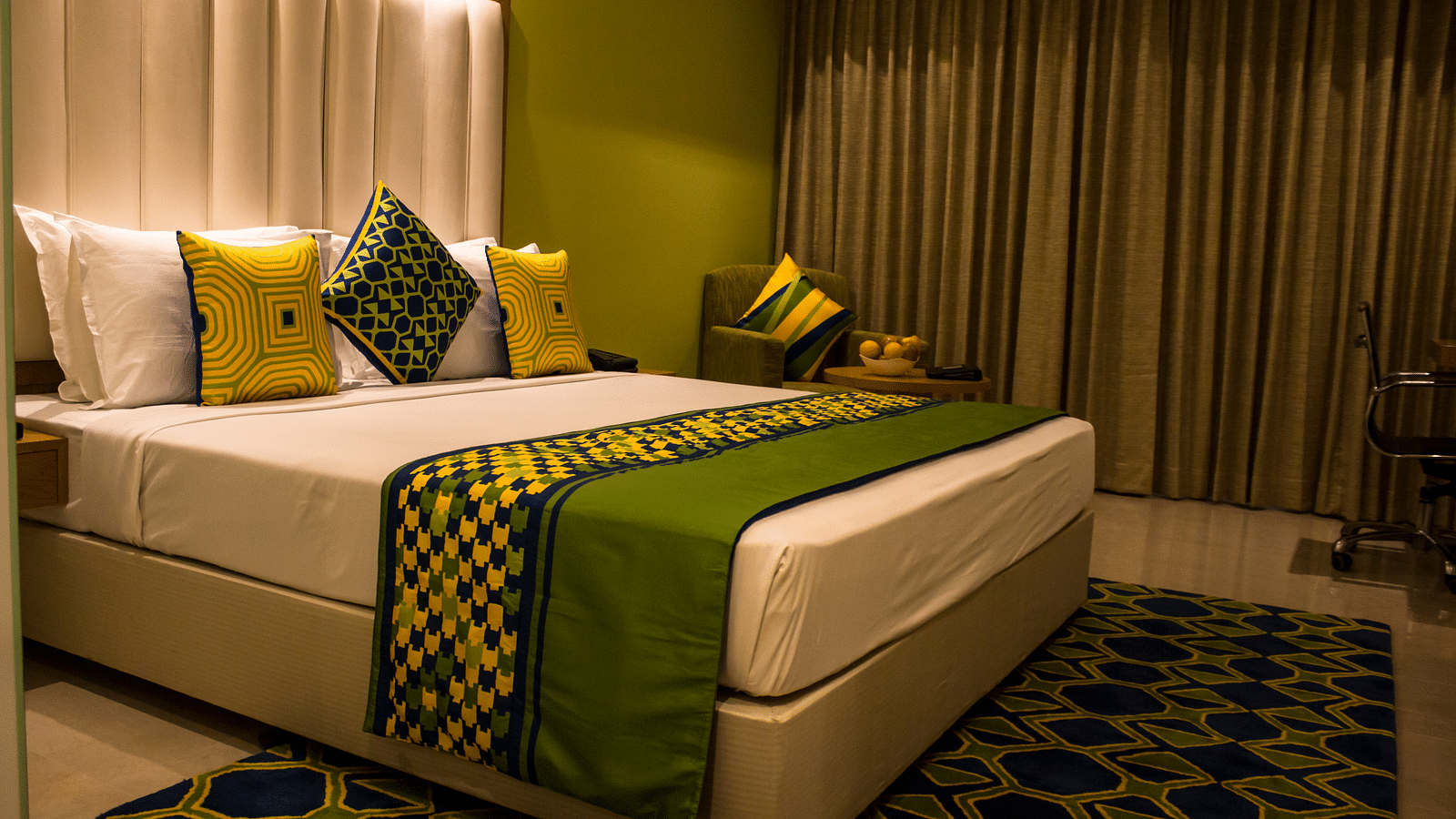 Image of a room with a bed and  pillows arranged on it  along with  a balcony | Regency Tirunelveli By GRT Hotels