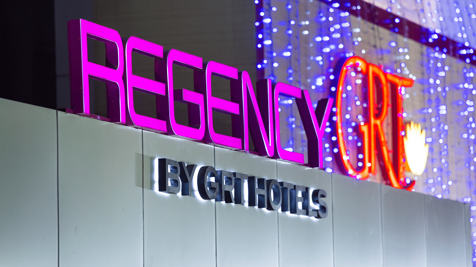 Regency GRT Hotels sign with purple letters and blue lights.