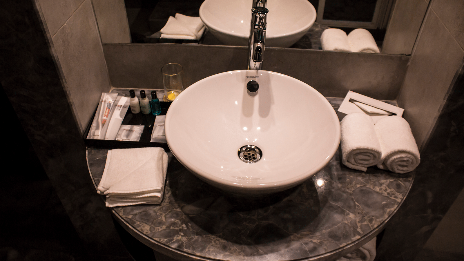 Image of a bathroom with a sink, mirrors  and towels | Regency Tirunelveli By GRT Hotels