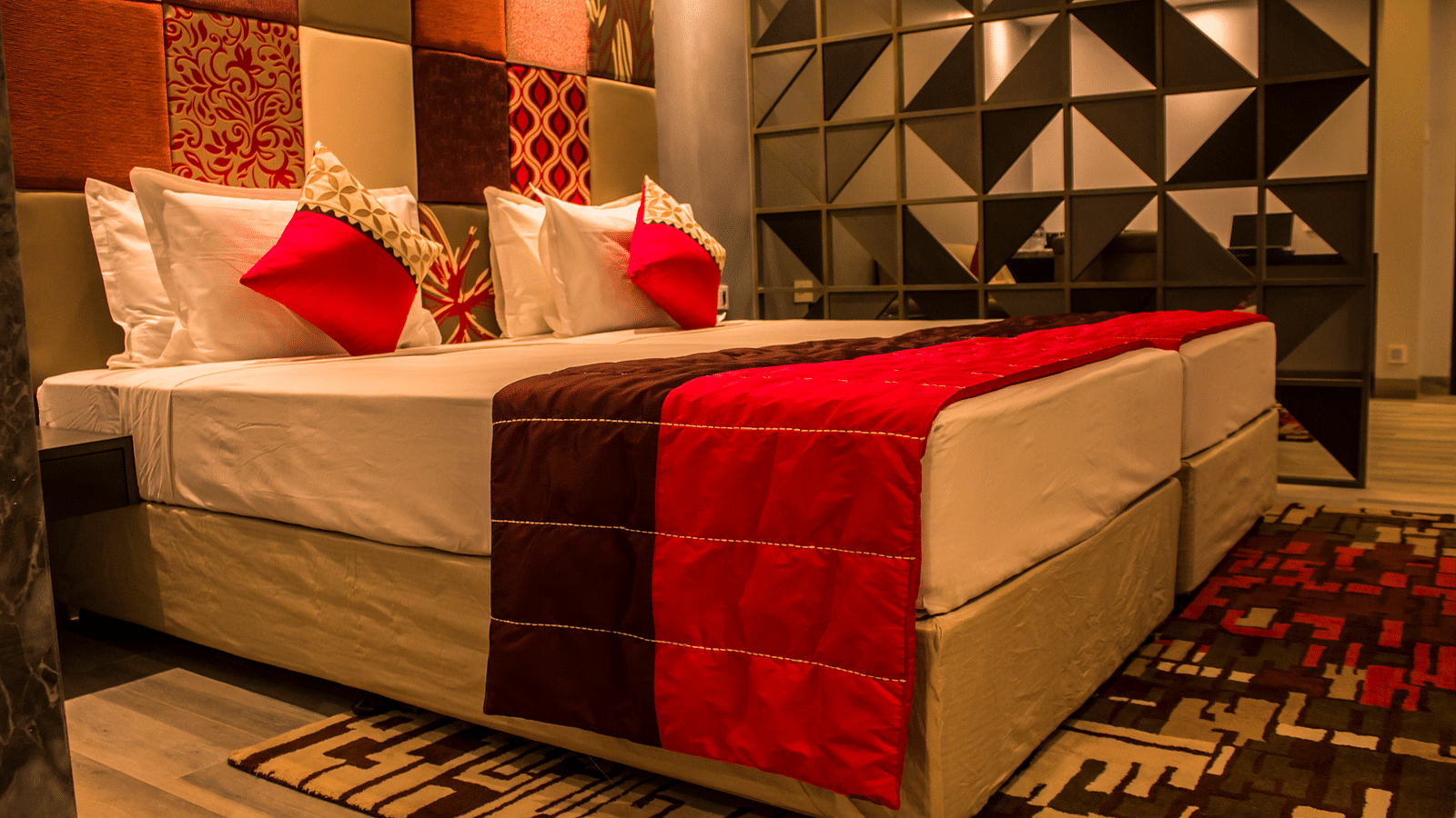 lower angle image of a room with twin beds and  pillows arranged on it  | Regency Tirunelveli By GRT Hotels