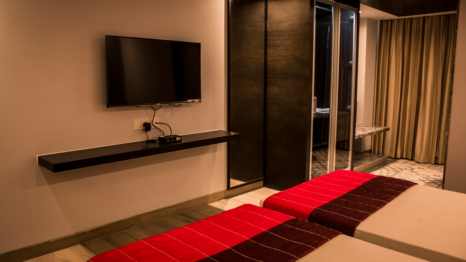 Side view of a room with twin beds and  pillows arranged on it  | Regency Tirunelveli By GRT Hotels