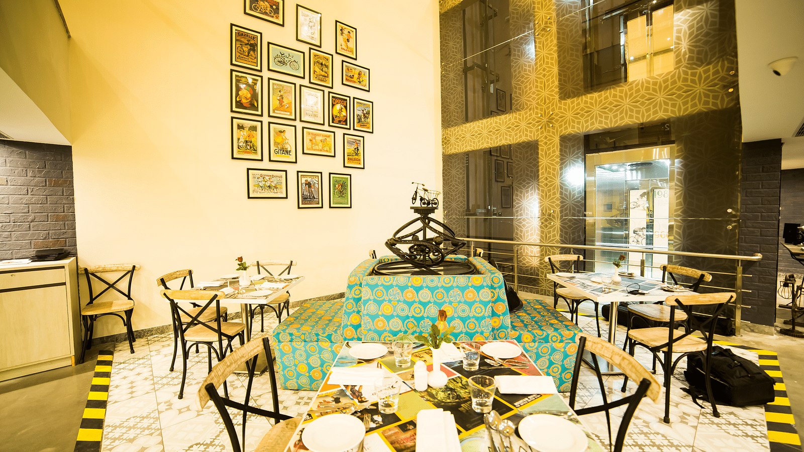 A restaurant interior with a central fountain surrounded by tables and chairs. The walls are adorned with framed pictures.