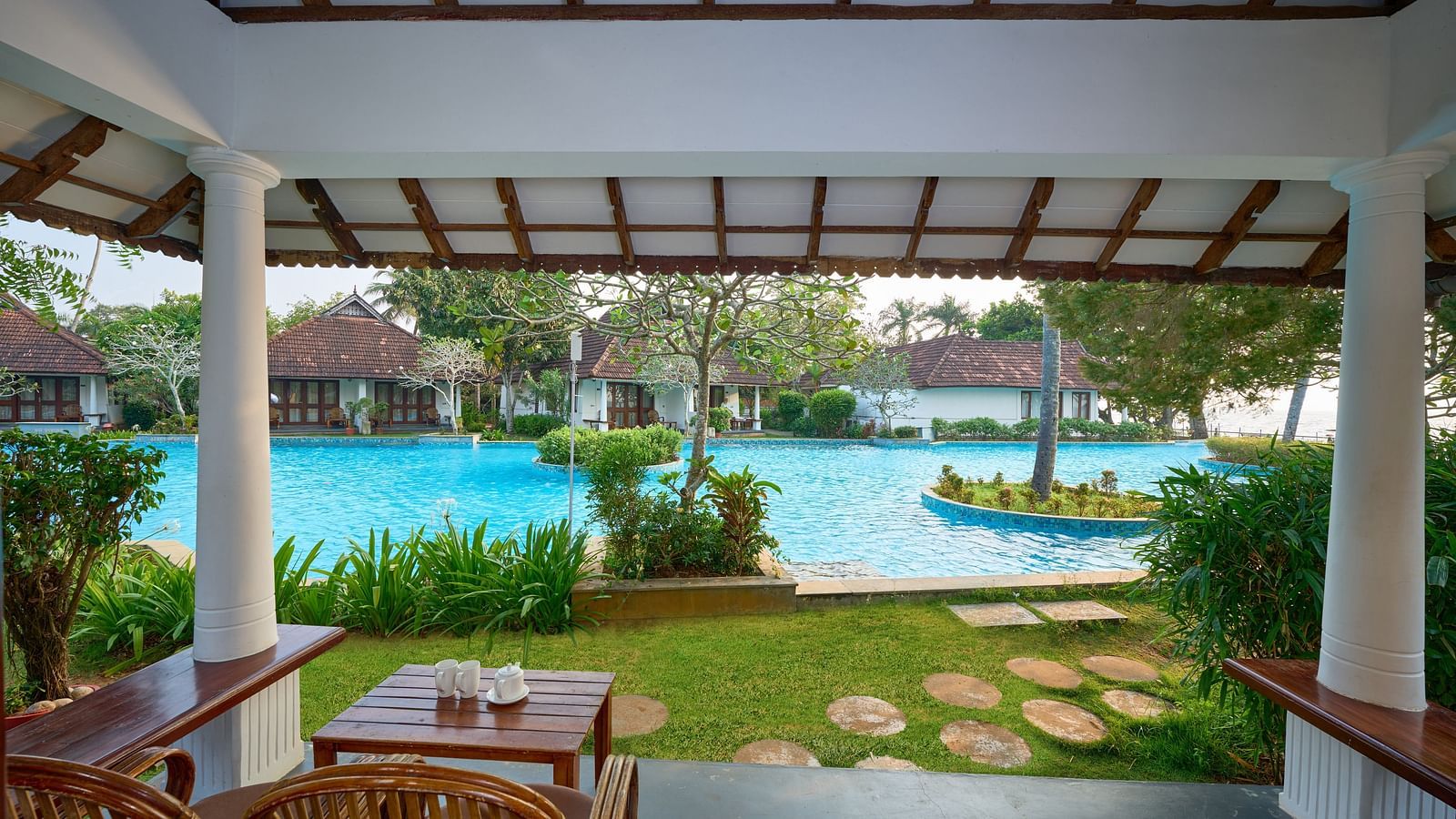 a view from inside a balcony of the swimming pool - Rhythm Kumarakom