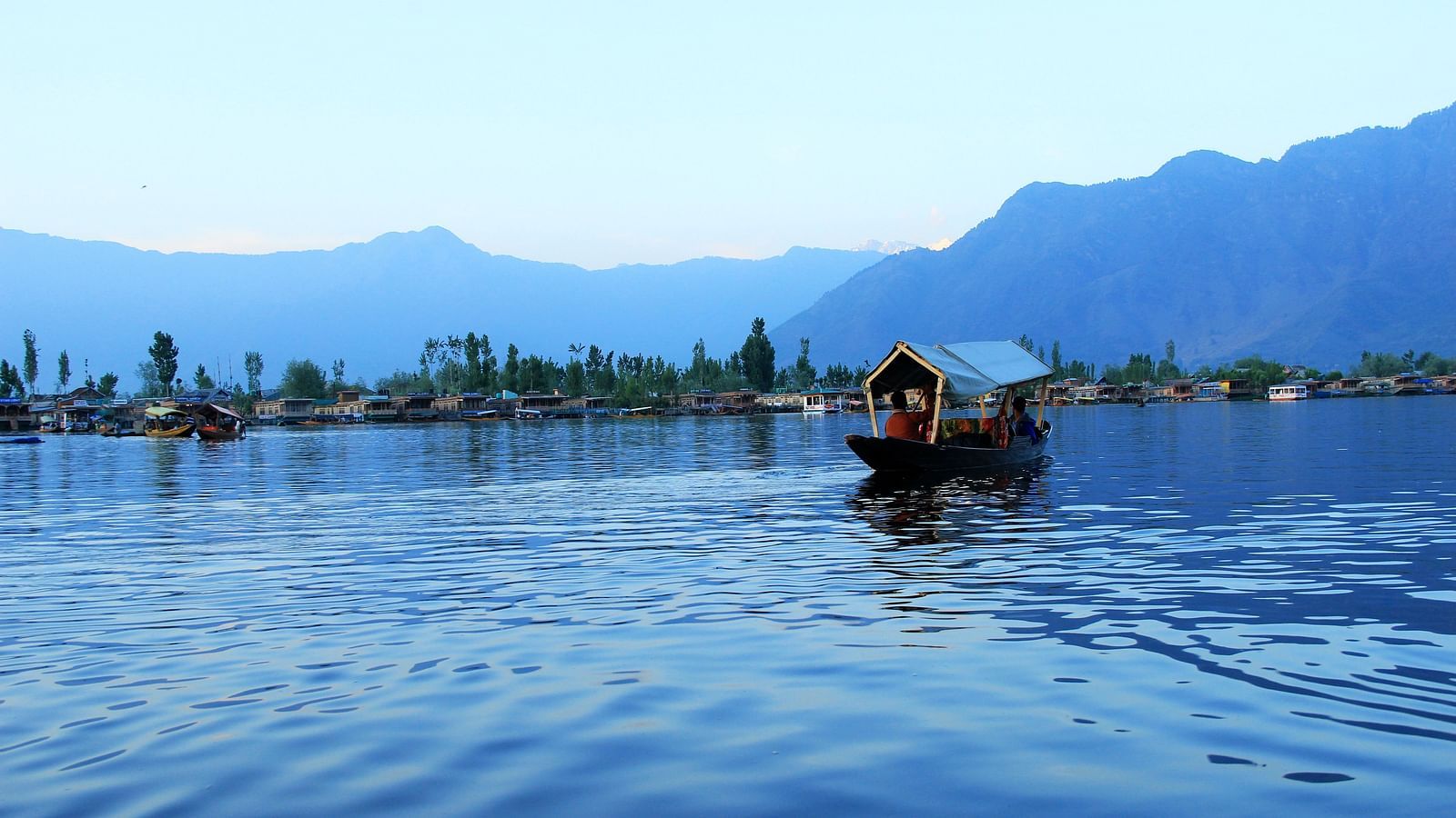 People sitting inside the shikara boats taking in the beautiful surroundings