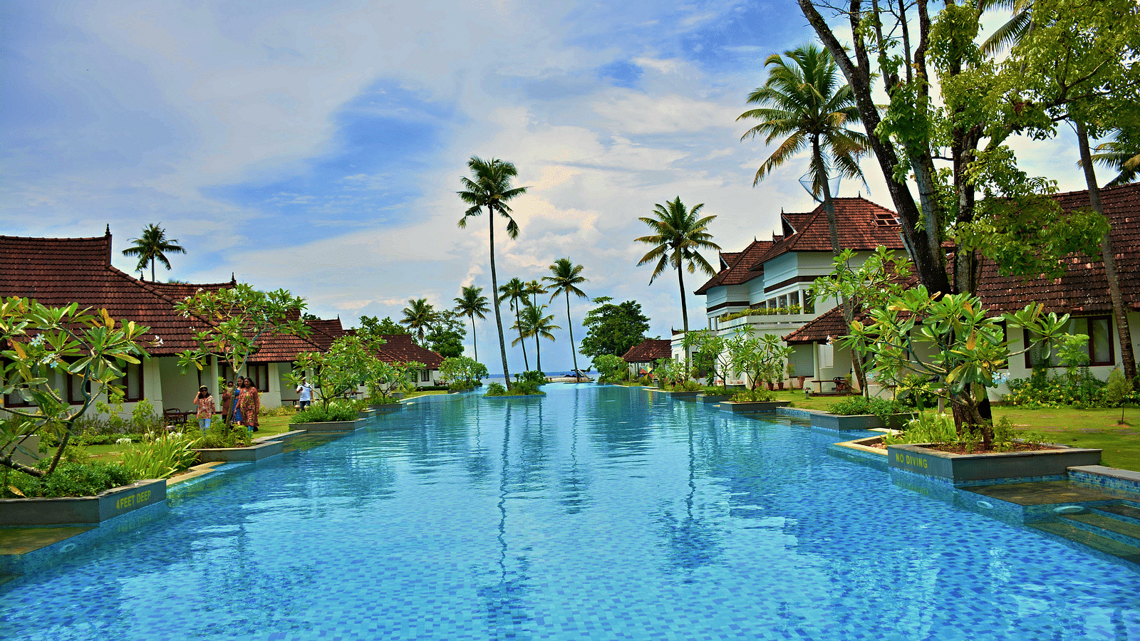 Swimming pool in the centre with resort buildings on the sides - Rhythm Lonavala