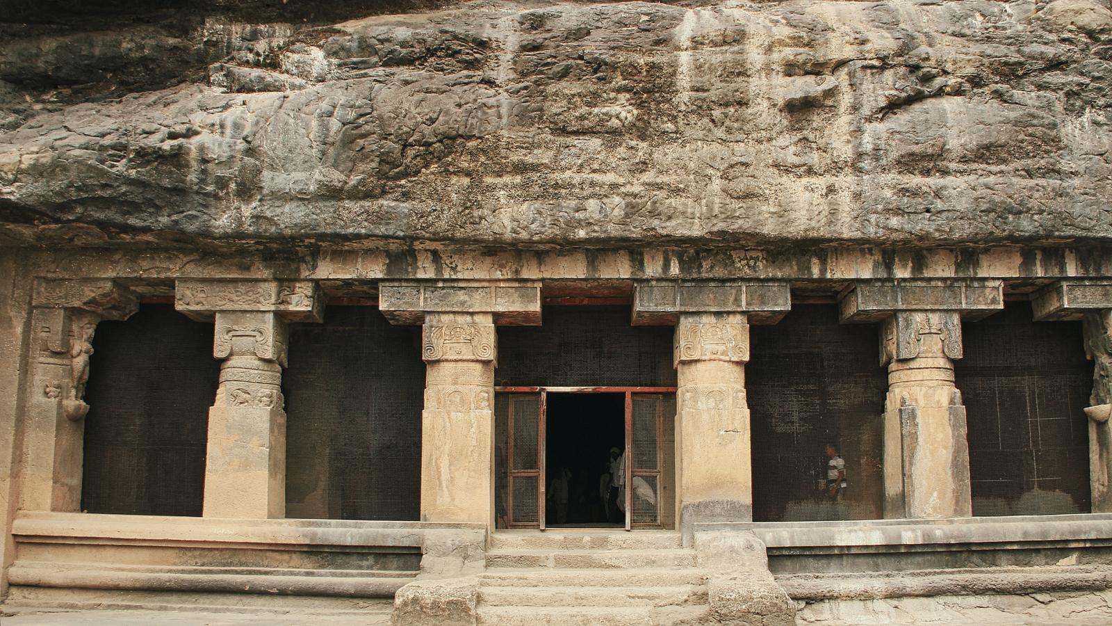 an overview of bhaja caves in lonavala with a door leading inside.