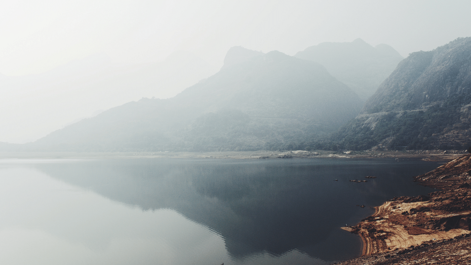 an overview of a lake with mountains in the background
