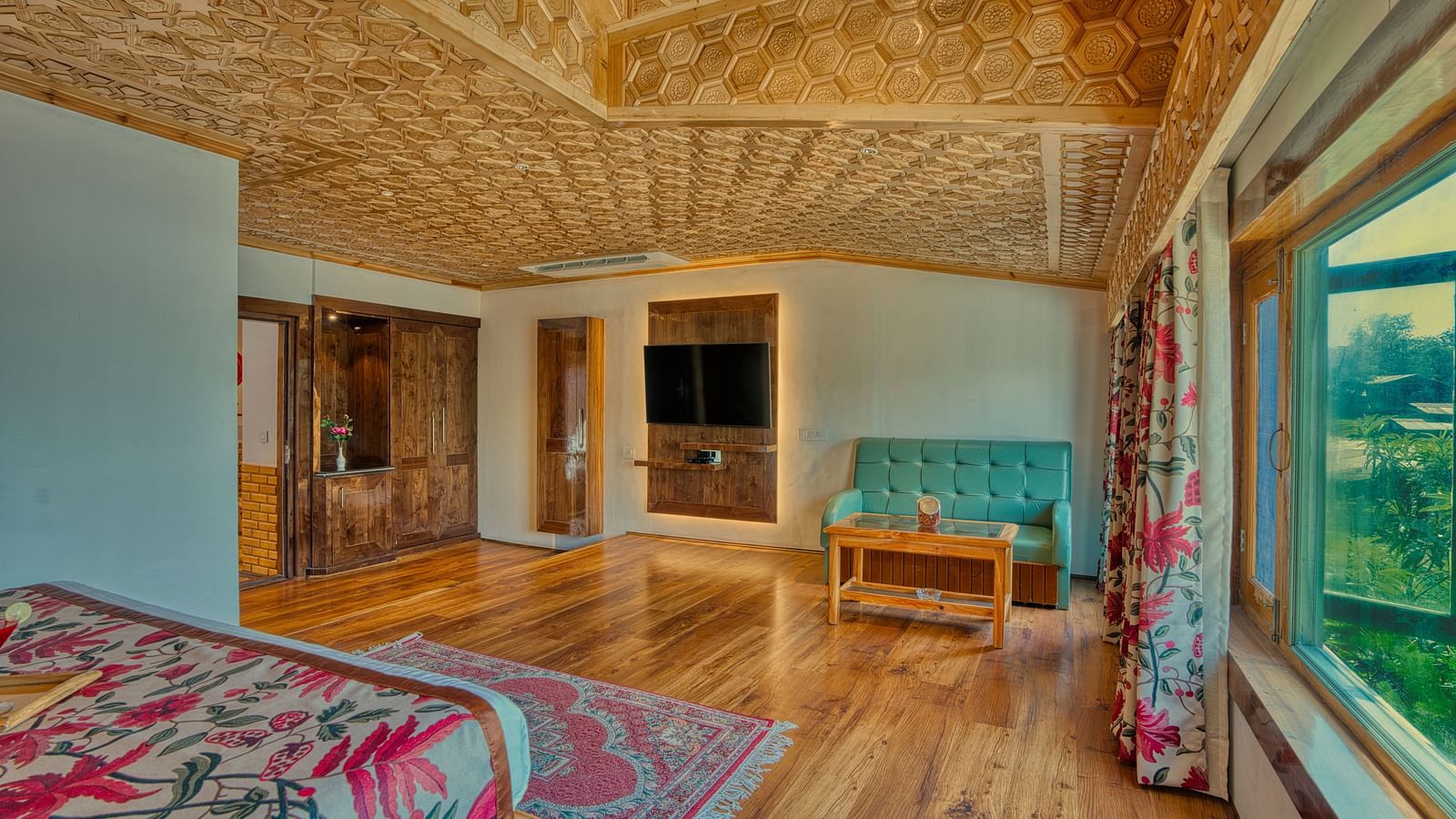 Open suite at Royal Comfort Regency with large windows, warm lighting and elegant wooden interiors for modern comfort.