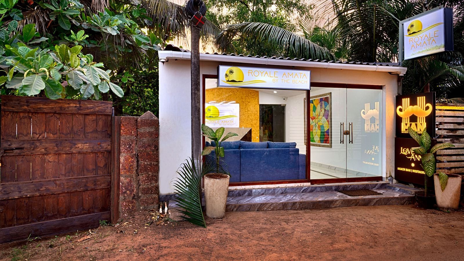 A peaceful courtyard with lush greenery and a wooden entrance.