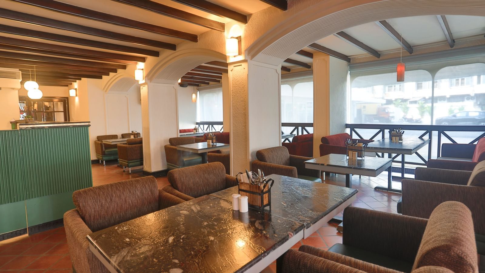 An inviting restaurant interior at Shilton International, Kochi, features a mix of dining tables and lounge seating, with a bar area.