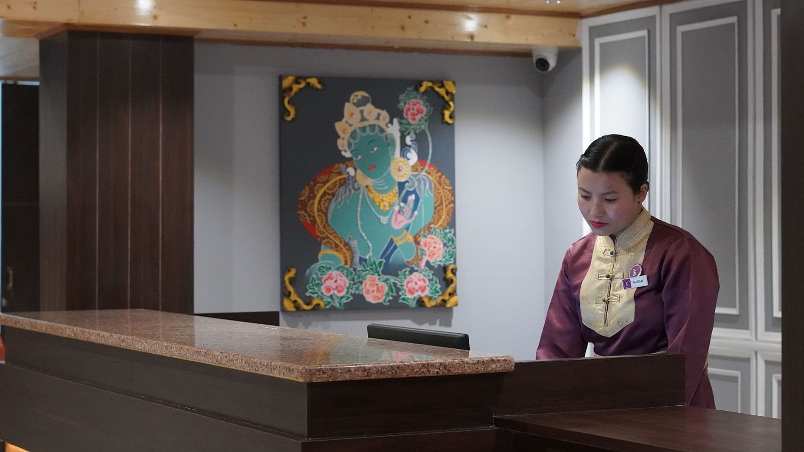 a woman welcoming at the reception desk at Sumitel Pelling, Geyzing
