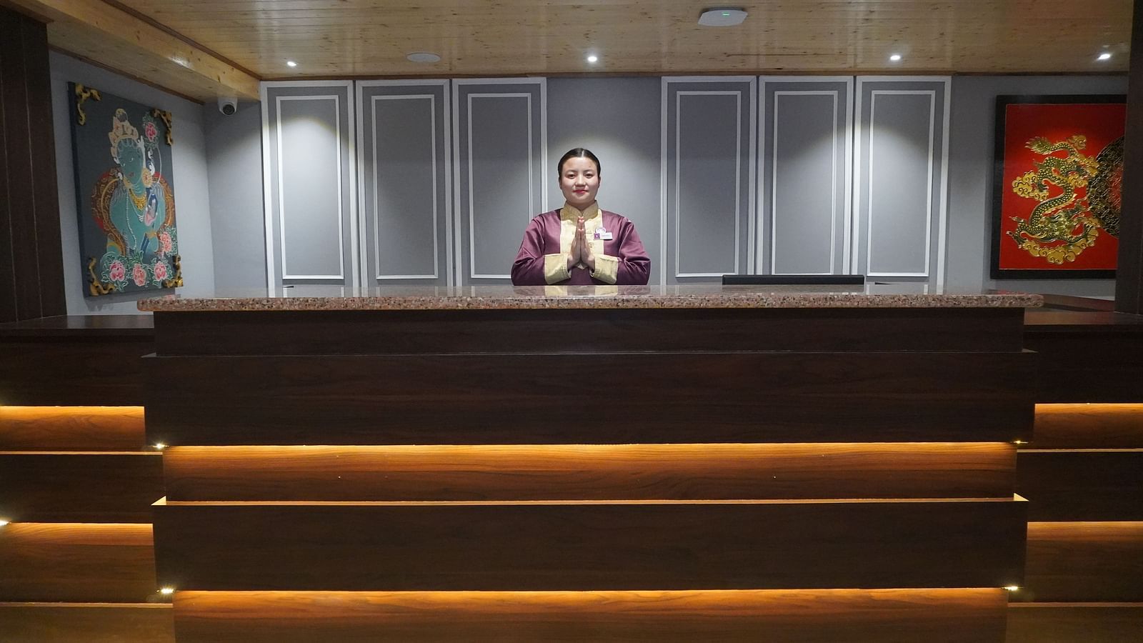 a woman welcoming at the reception desk at Sumitel Pelling, Geyzing