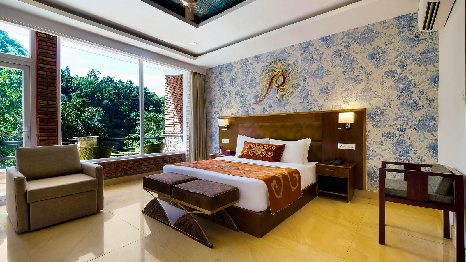 Side view of a room with bed and sitting area with large windows at Summit By The Ganges Beach Resort & Spa, Rishikesh