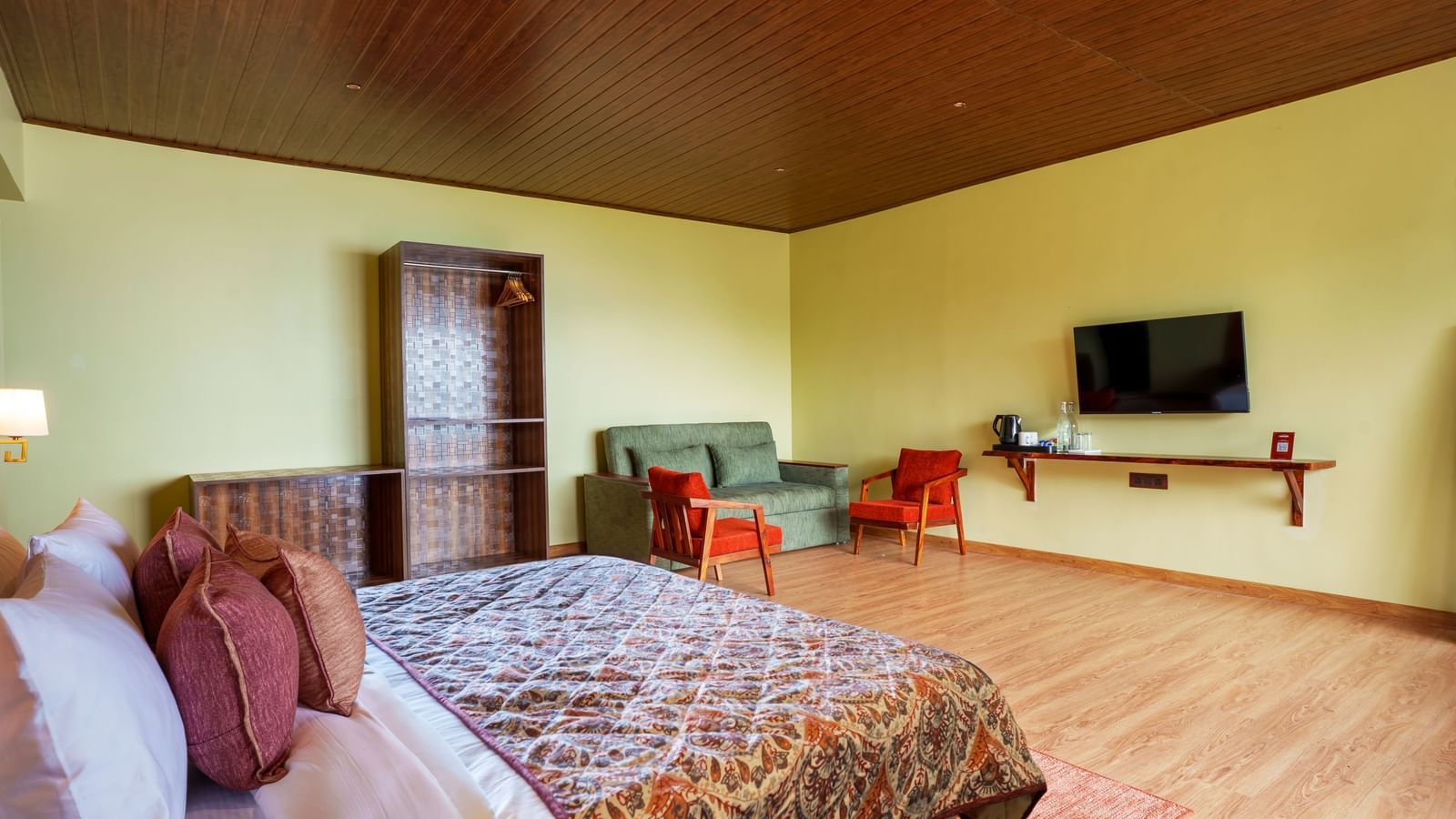Cosy bedroom with a double bed, flat-screen TV, wooden desk, and warm decor.