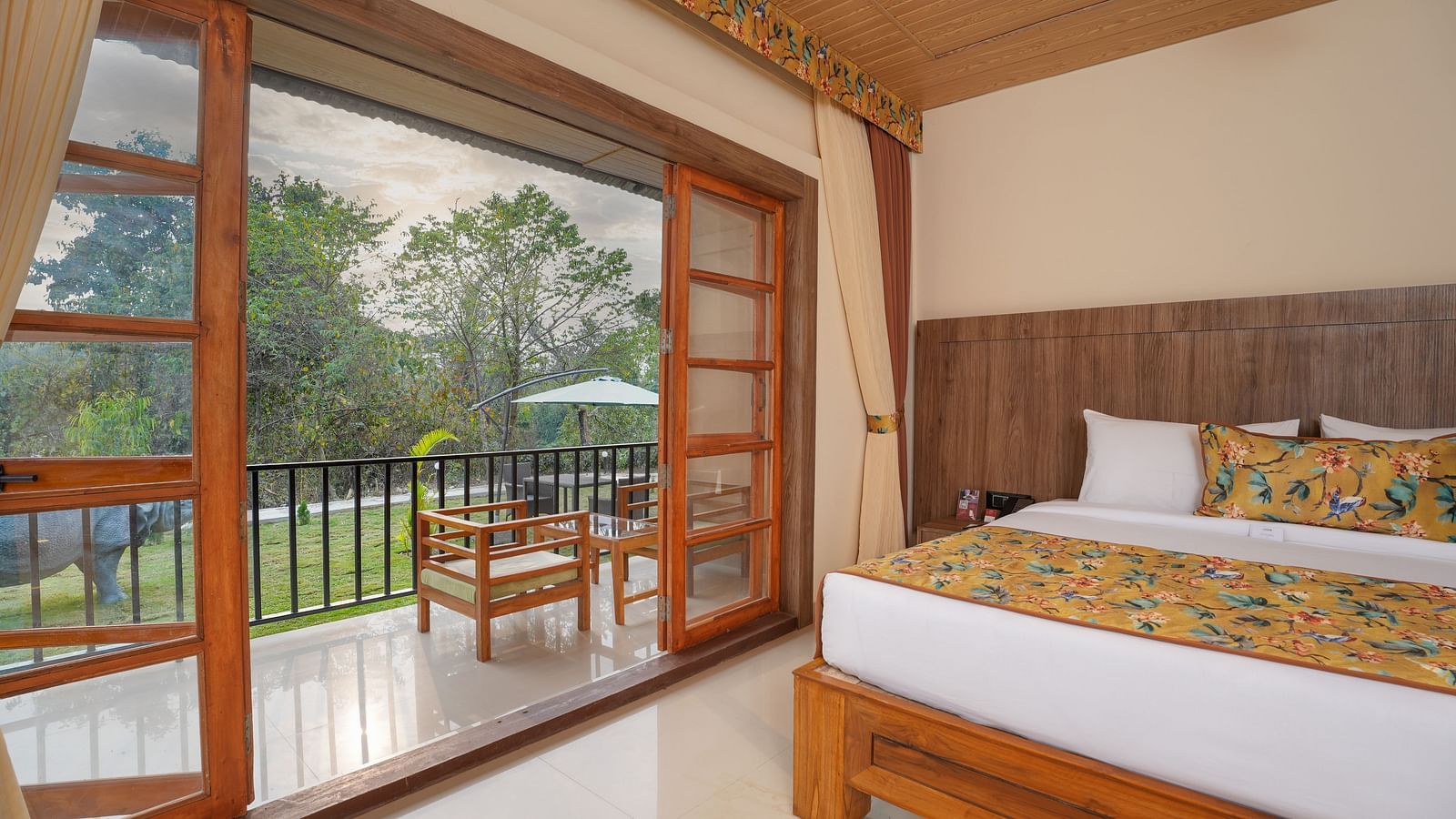 Bungalow featuring a spacious bed and a large balcony at Summit Green Lake Tea Resort & Spa, Kaziranga