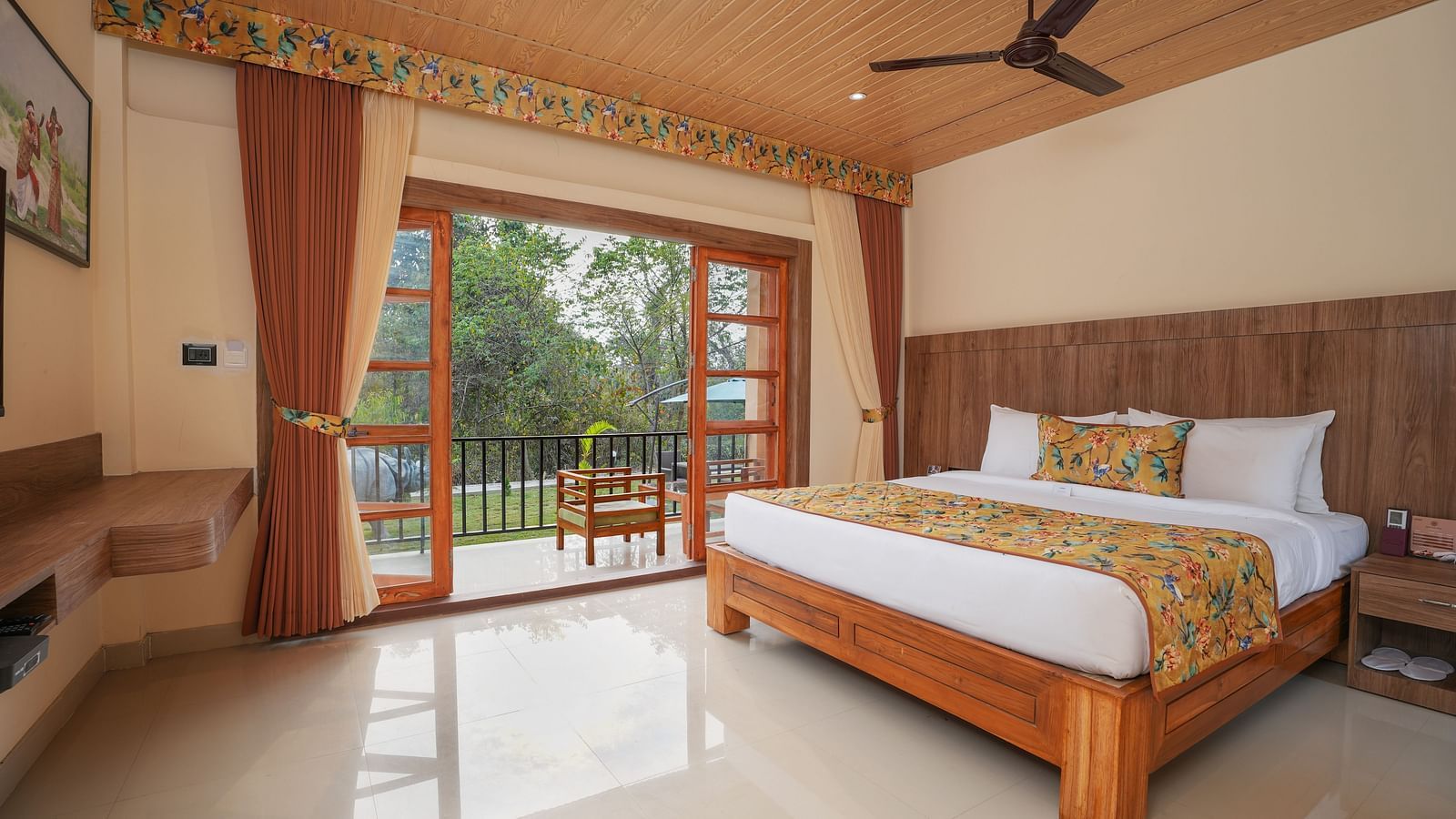 Bungalow featuring a spacious bed with a wall-mounted television and a large balcony with nature view at Summit Green Lake Tea Resort & Spa, Kaziranga