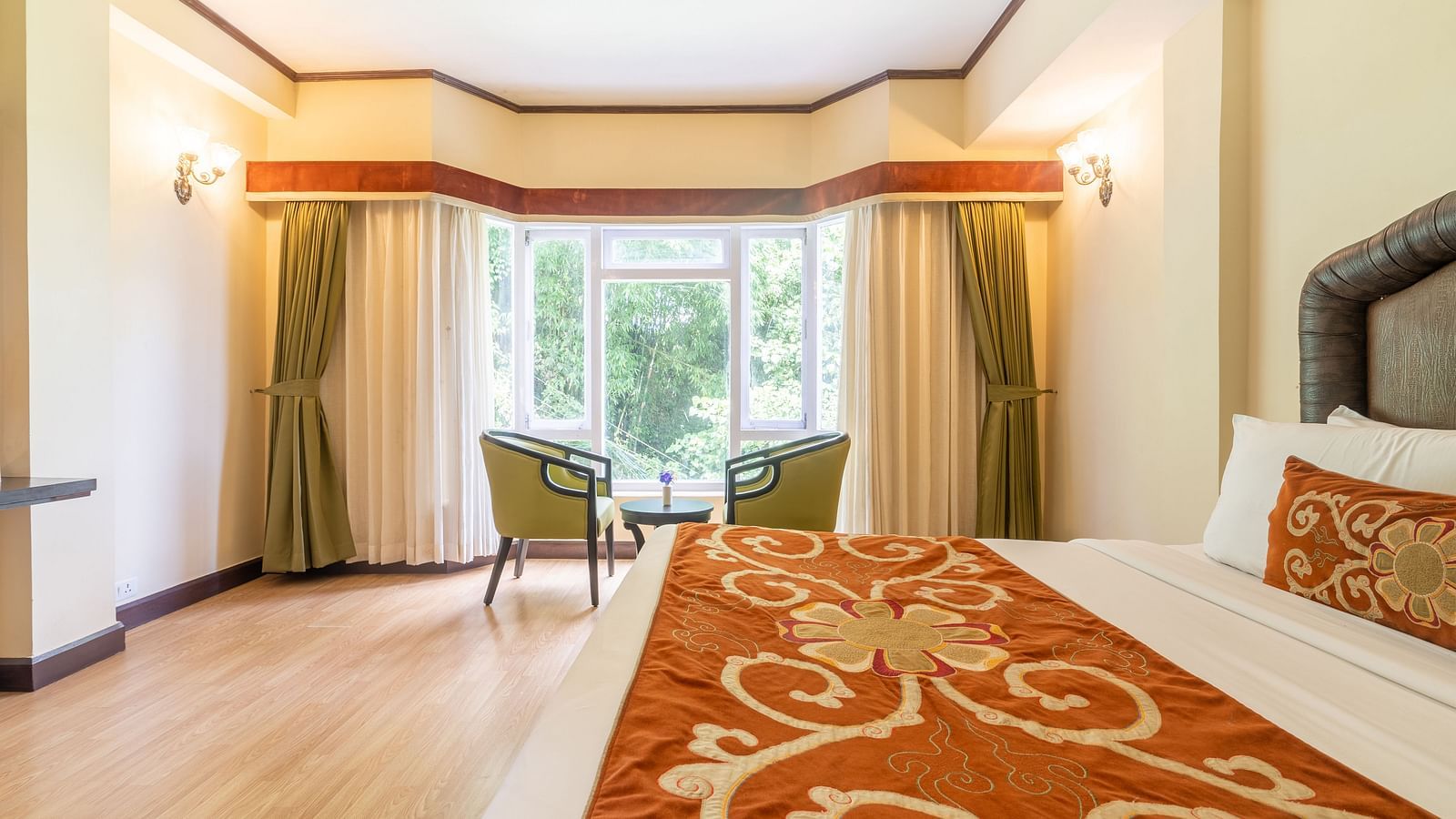 king size bed  with chairs near balcony of deluxe bed at Summit Lillium Hotel & Spa, Kalimpong