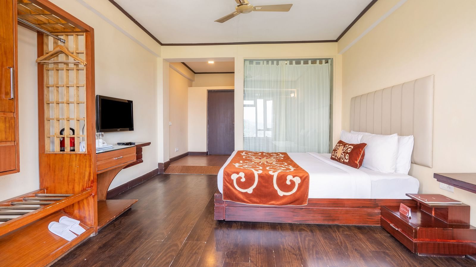 king size bed and TV of premium room at Summit Lillium Hotel & Spa, Kalimpong