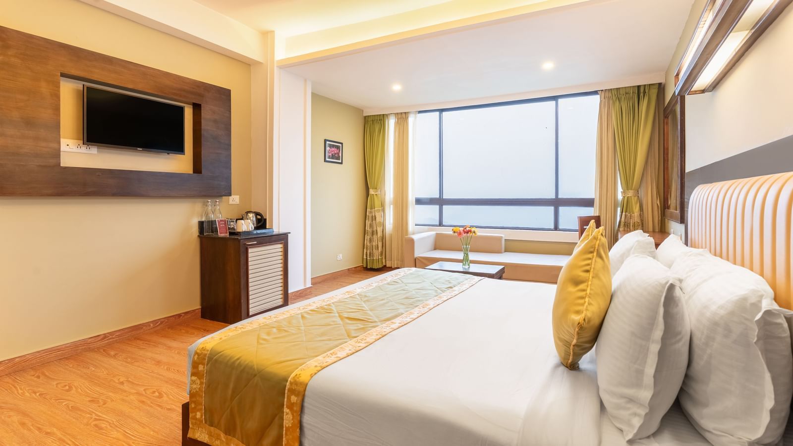 Deluxe Room at Summit North Star, Gangtok featuring a bed, a flat TV screen, a cabinet with tea and coffee maker, and a large window with outdoor view.